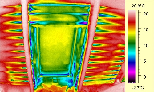 Termogram okna: wyraźna ucieczka ciepła wzdłuż ramy i szczeliny montażowej